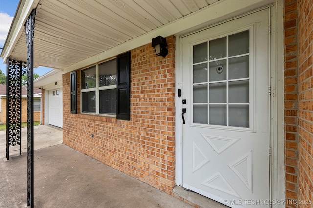 property entrance featuring a porch and brick siding