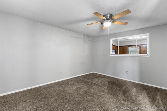 spare room with a ceiling fan, carpet flooring, and baseboards