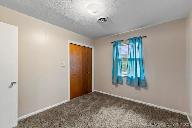 unfurnished bedroom with a closet, carpet flooring, baseboards, visible vents, and a textured ceiling