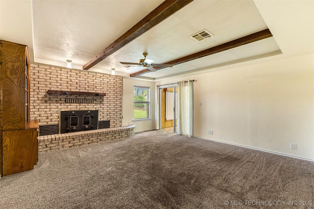 unfurnished living room with beam ceiling, a brick fireplace, ceiling fan, visible vents, and carpet floors