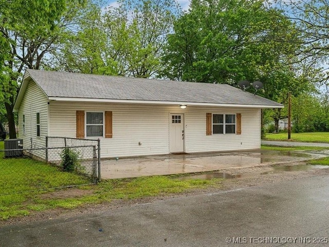 ranch-style house featuring central AC, fence, and a front yard