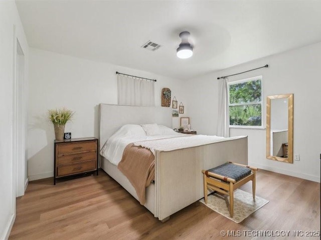 bedroom with baseboards, visible vents, and light wood-type flooring