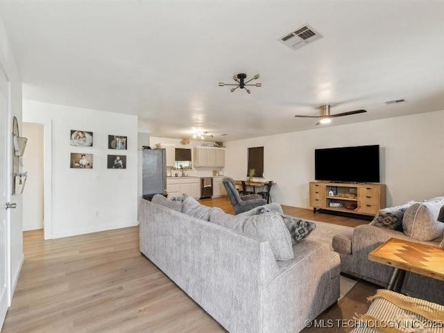 living area featuring visible vents, ceiling fan, and light wood-type flooring