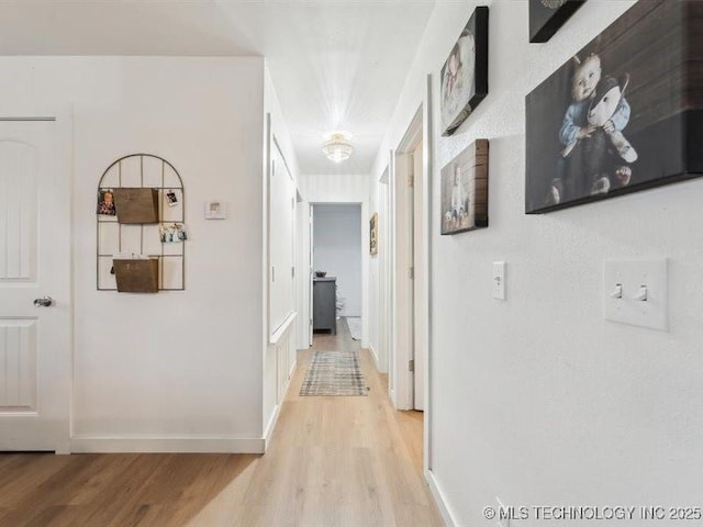 hallway with light wood finished floors and baseboards