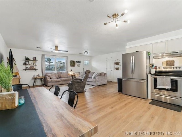 dining space with ceiling fan and light wood-style floors