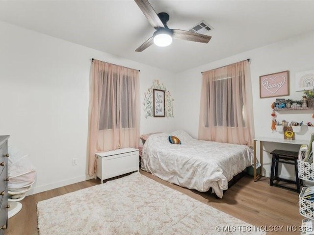 bedroom featuring visible vents, ceiling fan, and wood finished floors
