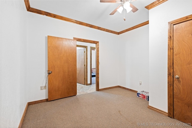 spare room featuring crown molding, baseboards, a ceiling fan, and carpet floors