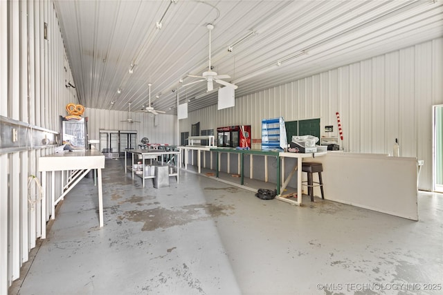 misc room featuring a ceiling fan and concrete flooring