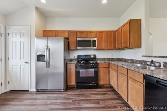 kitchen featuring dark wood finished floors, recessed lighting, brown cabinetry, black appliances, and a sink