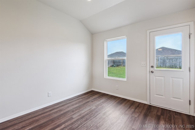 interior space featuring lofted ceiling, dark wood-style floors, and baseboards