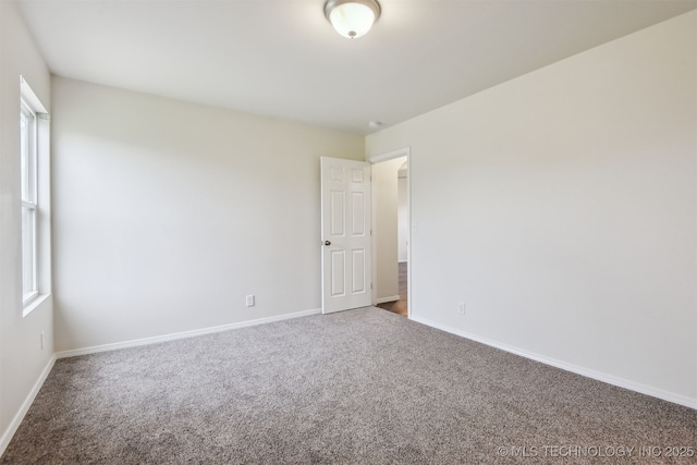 carpeted empty room with baseboards