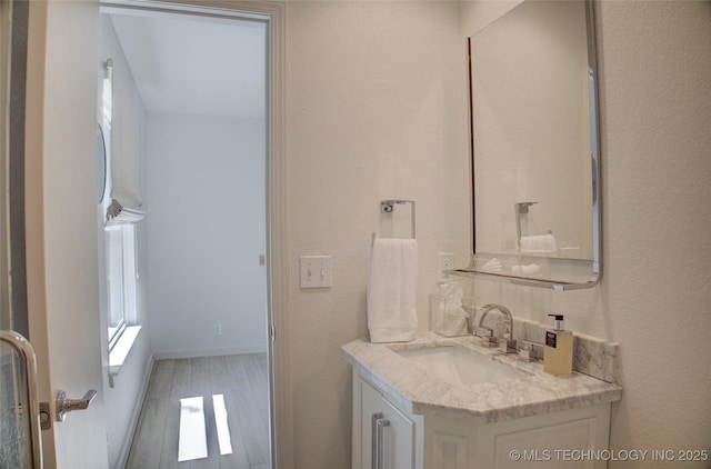 bathroom featuring a textured wall and vanity