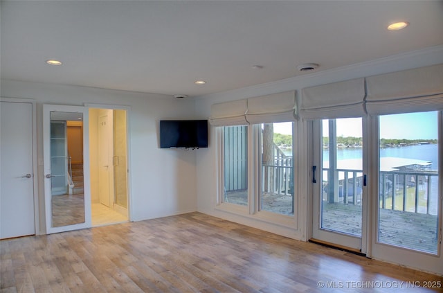interior space with wood finished floors, crown molding, recessed lighting, and baseboards