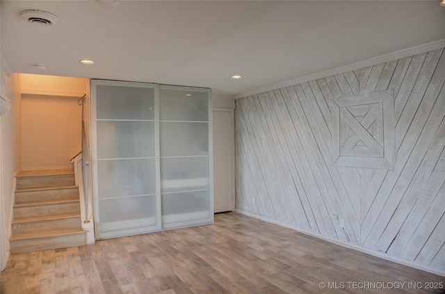 unfurnished bedroom featuring wooden walls, recessed lighting, visible vents, and wood finished floors