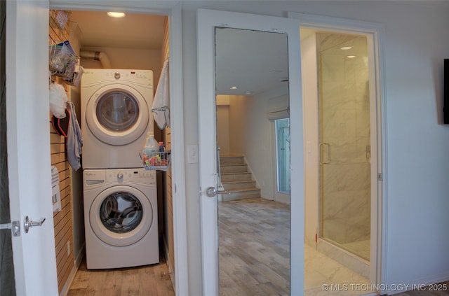 laundry area featuring stacked washer / drying machine, recessed lighting, laundry area, and wood finished floors