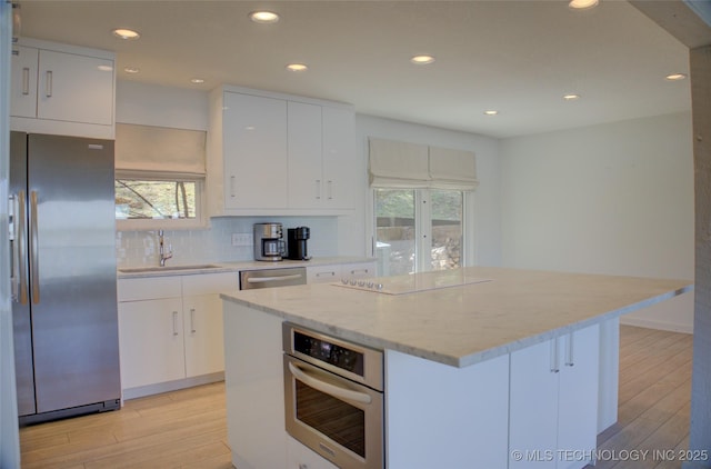 kitchen with light wood-style flooring, a sink, a wealth of natural light, and stainless steel appliances