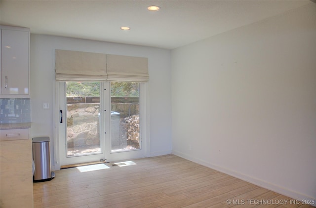 unfurnished dining area featuring light wood-style floors, recessed lighting, and baseboards