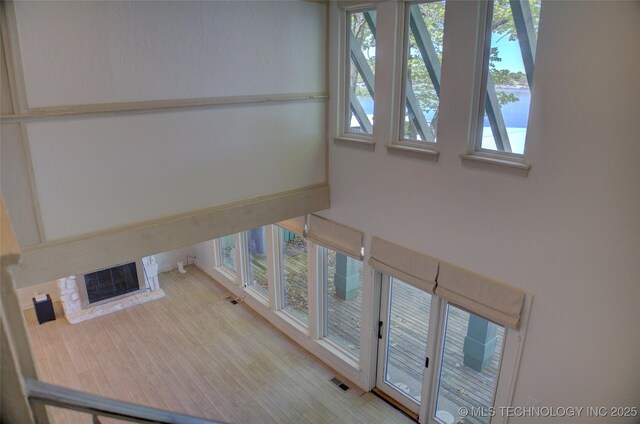stairway with a glass covered fireplace and visible vents