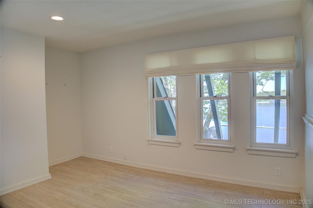 spare room featuring baseboards, light wood-type flooring, and recessed lighting