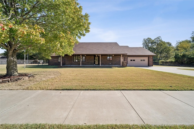 601 N Okmulgee Ave, Okmulgee, OK 74447 - ranch-style house with driveway, a front lawn, brick siding, and an attached garage