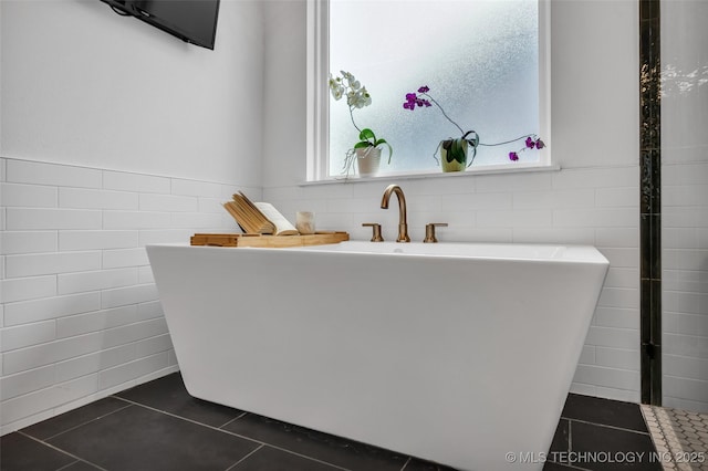 11529 S Marion Ave, Tulsa, OK 74137 - bathroom with tile walls, tile patterned floors, a freestanding tub, and a wainscoted wall
