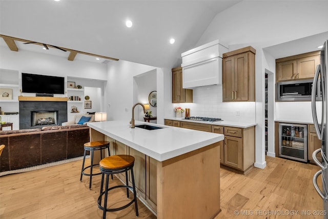 11529 S Marion Ave, Tulsa, OK 74137 - kitchen featuring a sink, beverage cooler, appliances with stainless steel finishes, light wood-type flooring, and vaulted ceiling