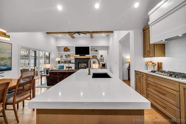 11529 S Marion Ave, Tulsa, OK 74137 - kitchen with a sink, wall chimney exhaust hood, light countertops, stainless steel gas cooktop, and tasteful backsplash