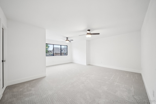 carpeted empty room with a ceiling fan and baseboards
