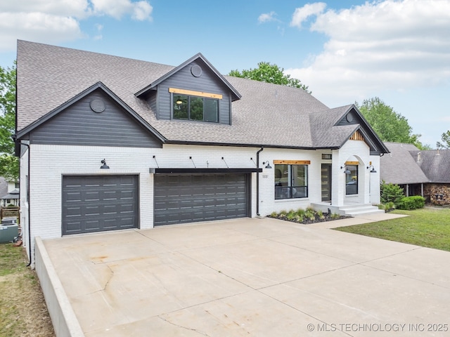 view of front of property with driveway, a shingled roof, an attached garage, and brick siding