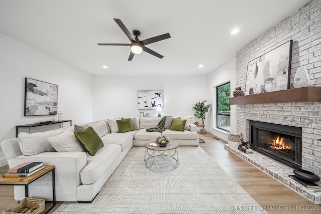 living room featuring a fireplace, wood finished floors, a ceiling fan, and recessed lighting