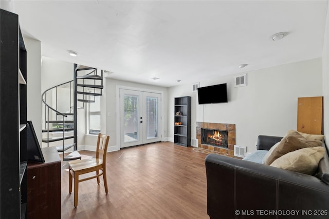 living area featuring stairway, visible vents, wood finished floors, and baseboards