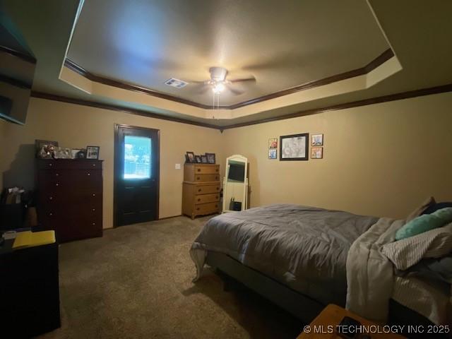 bedroom featuring visible vents, a raised ceiling, ornamental molding, and carpet flooring