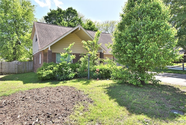 705 W Boston St, Broken Arrow, OK 74012 - view of side of property featuring fence, roof with shingles, a yard, and brick siding