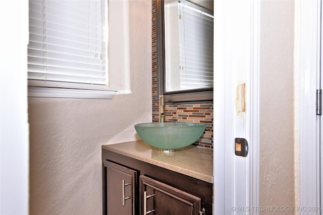 705 W Boston St, Broken Arrow, OK 74012 - bathroom with tasteful backsplash, a textured wall, and vanity