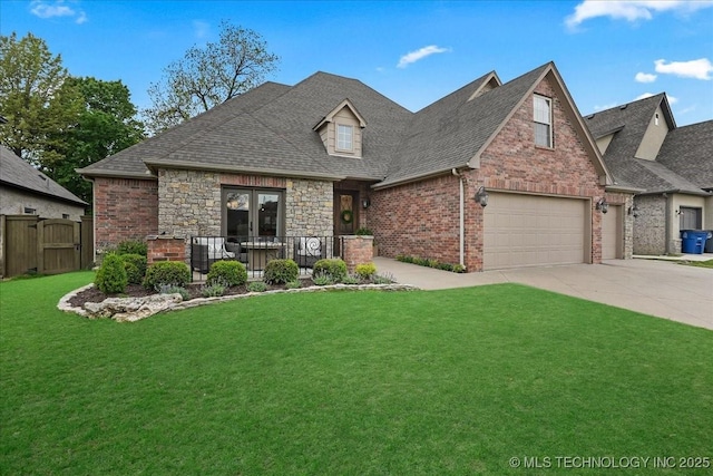 view of front facade featuring a front lawn, a shingled roof, driveway, brick siding, and fence