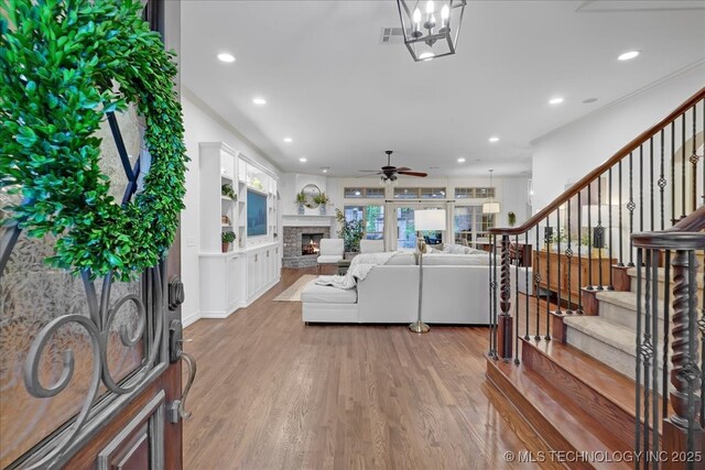 living area with recessed lighting, stairway, light wood-style floors, a fireplace, and a ceiling fan