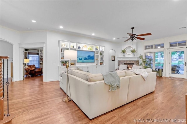 living room featuring recessed lighting, light wood-style floors, a fireplace, a ceiling fan, and visible vents