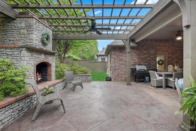 view of patio featuring ceiling fan, fence, outdoor dining space, and an outdoor stone fireplace