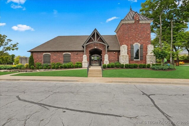 view of front of home with a front yard and brick siding