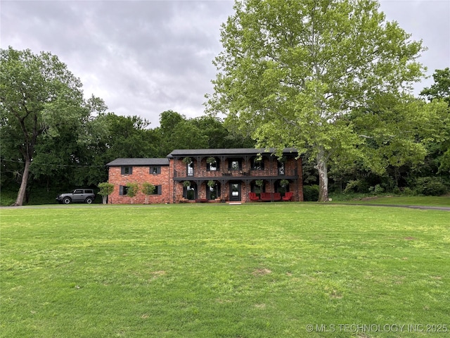 view of front of property with brick siding, a porch, and a front lawn