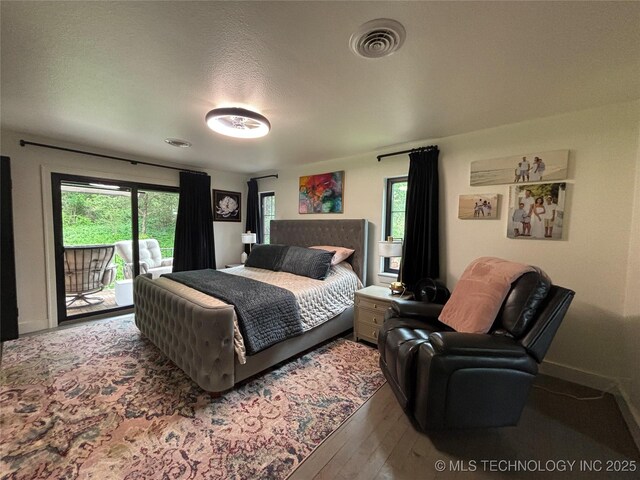 210 Woods Ln, Ardmore, OK 73401 - bedroom with multiple windows, wood finished floors, visible vents, and access to exterior