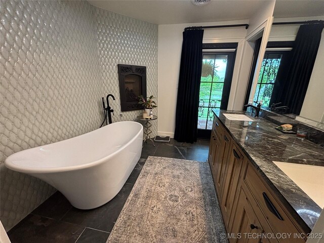 full bathroom with a soaking tub, wallpapered walls, tile patterned flooring, and a sink