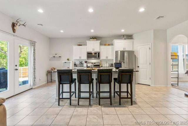 7305 S Walnut Ave, Broken Arrow, OK 74011 - kitchen with appliances with stainless steel finishes, backsplash, white cabinets, light tile patterned floors, and recessed lighting