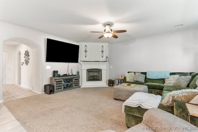 7305 S Walnut Ave, Broken Arrow, OK 74011 - tiled living area featuring arched walkways, ceiling fan, and a fireplace