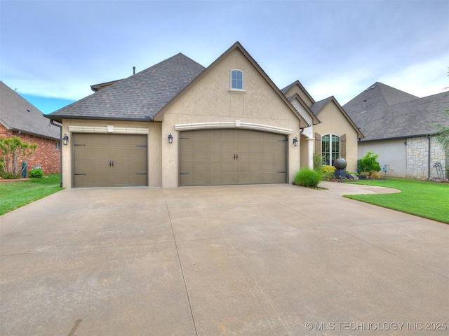 16321 E 48th Pl, Tulsa, OK 74134 - french country home featuring concrete driveway, a shingled roof, stucco siding, a front lawn, and a garage