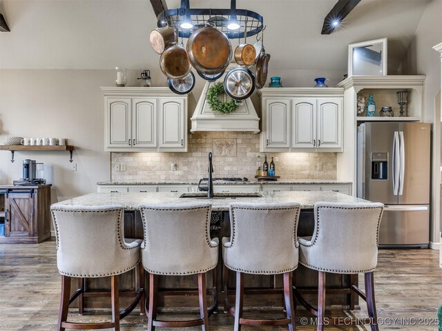 16321 E 48th Pl, Tulsa, OK 74134 - kitchen with a kitchen island with sink, light stone countertops, backsplash, and stainless steel fridge with ice dispenser