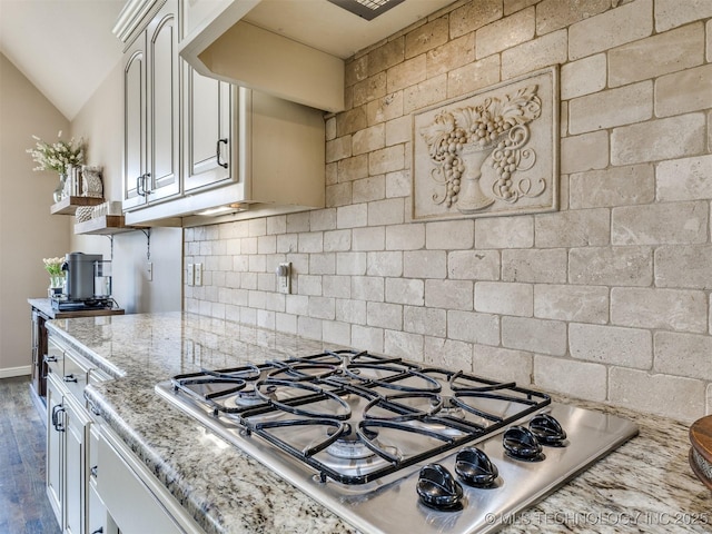 16321 E 48th Pl, Tulsa, OK 74134 - kitchen featuring light stone countertops, stainless steel gas cooktop, vaulted ceiling, backsplash, and dark wood-type flooring