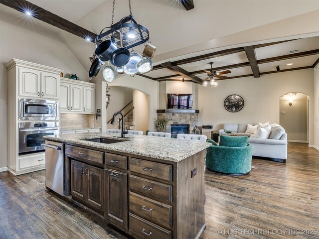 16321 E 48th Pl, Tulsa, OK 74134 - kitchen with arched walkways, a sink, a ceiling fan, and stainless steel appliances