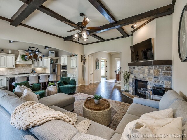 16321 E 48th Pl, Tulsa, OK 74134 - living area with dark wood-style floors, baseboards, beam ceiling, arched walkways, and a ceiling fan