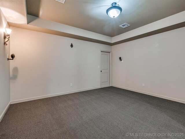 16321 E 48th Pl, Tulsa, OK 74134 - unfurnished room featuring dark carpet, visible vents, a tray ceiling, and baseboards